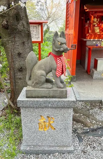 Statue d'un ktsune avec une clé dans la bouche